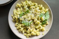 a white bowl filled with pasta and spinach