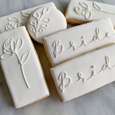 four decorated cookies with the word bride on them