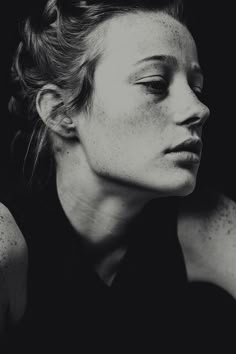 a black and white photo of a woman with freckles on her hair looking to the side