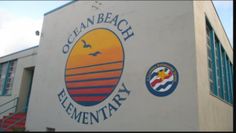 the ocean beach elementary building is white with blue and orange stripes on it's side