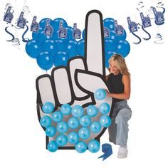 a woman standing next to a sign with balloons in the shape of a peace hand