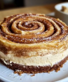 a close up of a cake on a plate with powdered sugar and cinnamon swirl