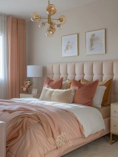 a bed with pink sheets and pillows in a bedroom