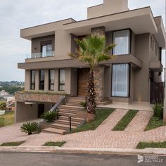 a house that is on the side of a road with palm trees in front of it