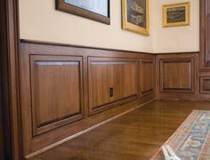 an empty room with wood paneling and pictures on the wall