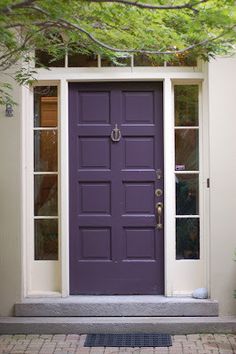 a purple front door on a white house