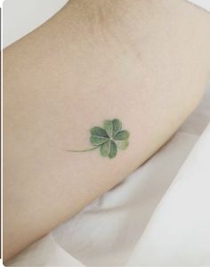 a small four leaf clover tattoo on the right arm and foot, with green ink