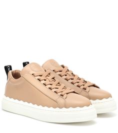 With scalloped trim running around the elevated sole, and embossed logo detailing on the tongue, Chloe's Lauren sneaker silhouette taps into the brand's bohemian styling while maintaining a clean sports-luxe look. This pair has been crafted in Spain from buttery soft "pink tea" leather, with contrasting white soles for instant visual impact. Wear yours with a kick-hem miniskirt for a sense of insouciant chic. | Chloé Lauren leather sneakers Chic Heels, Pink Tea, Chloe Shoes, Sports Luxe, Pink Beige, Leather Items, Embossed Logo, Leather Sneakers, Shoes Online