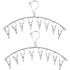 several pairs of scissors hanging from hooks on a white background, with clippings attached to them