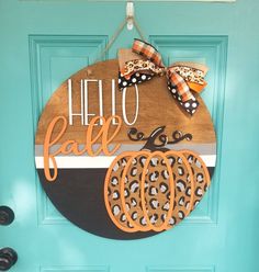 a hello fall door hanger is hanging on a blue door with an orange and black pumpkin