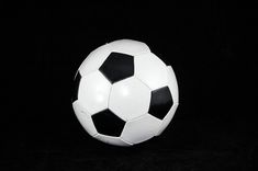 a black and white soccer ball on a black background