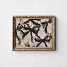 an abstract painting hanging on the wall in a gold frame with black and white paint