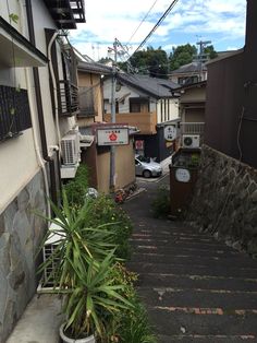 an alley way with stairs leading up and down to the building on the right side