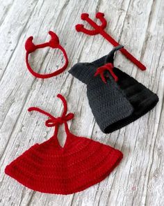 three crocheted hats and two ties on a wooden surface