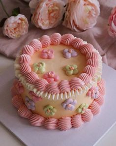 a pink and white cake sitting on top of a table