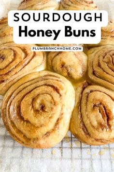 some cinnamon rolls on a cooling rack with the words sourdough honey buns