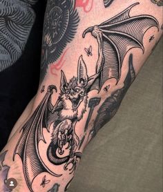 a man's arm with a bat tattoo on it, and an image of a demon