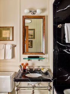 a bathroom with a sink, mirror and toilet in it's centerpieces