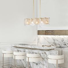 a kitchen with marble counter tops and bar stools in front of a chandelier