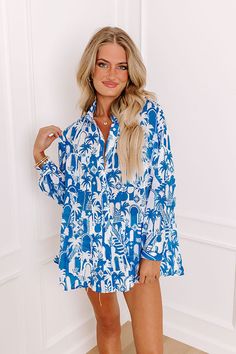 - Add a touch of the tropics to your wardrobe with this chic button-up! With its lightweight material and tropical-themed print, this piece is perfect for a walk down a breezy boardwalk. Whether you're heading to a beachside cafe or enjoying a sunset cruise, this shirt brings a vacay vibe to any occasion. - Unlined semi-sheer lightweight material with an abstract tropical cityscape print - A collared neckline - A button up front - Long sleeves with button closure cuffs - Functional chest pockets Blue Floral Print Hawaiian Shirt For Beach, Summer Long Sleeve Printed Hawaiian Shirt, Summer Vacation Hawaiian Button-up Shirt, Summer Hawaiian Shirt Long Sleeve Printed, Summer Hawaiian Button-up Shirt For Vacation, Blue Hawaiian Shirt With Hibiscus Print For Summer, Summer Beach Hawaiian Shirt With Button Closure, Blue Hawaiian Shirt With Hibiscus Print For Beach, Blue Button-up Hawaiian Shirt For Vacation