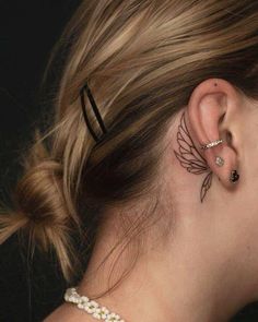 a woman's ear with an angel tattoo on her left side behind the ear