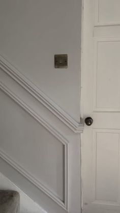 an open door in a room with white walls and carpeted floor, next to a stair case