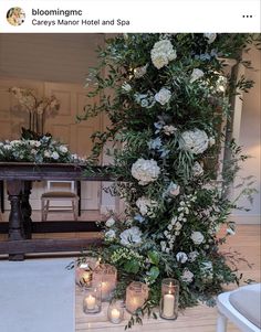 flowers and candles are arranged on the floor in front of a table with an altar