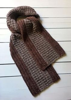 a knitted scarf laying on top of a wooden floor