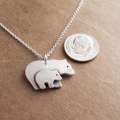 "My Mother and Baby Bear Necklace is handcrafted in fine silver. I create the mom and baby separately and then join them together. A little oxidation and a soft, brushed finish highlight the details. The back is stamped with my dragonfly maker's mark and \".999\" to signify fine silver. S I Z E : About 7/8\" across (22 mm) and 11/16\" tall (17 mm) including the ring. A V A I L A B I L I T Y : Made-to-order, ships 1-2 weeks after purchase unless otherwise noted above. Because I make each one by h Hand Stamped White Sterling Silver Necklaces, Hand Stamped Sterling Silver White Necklace, White Sterling Silver Hand Stamped Necklace, Bear Necklace, Mom Necklace, Maker's Mark, Mother And Baby, Baby Bear, Kids Jewelry