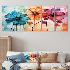 three colorful flower paintings on a wall in a living room