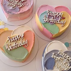 four heart shaped cakes with happy birthday written on them, all decorated in pastel colors