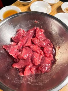 raw meat in a metal bowl on a wooden table