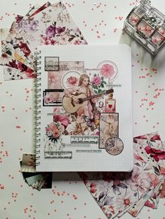 an open notebook sitting on top of a table covered in papers and stickers next to scissors