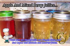 four jars filled with liquid sitting on top of a counter