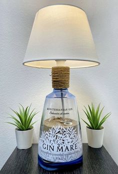 a lamp that is sitting on top of a table next to some potted plants