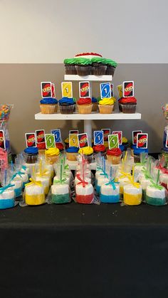 a table topped with lots of cupcakes covered in frosting and candy bars