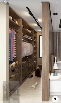 a walk in closet with clothes and shoes on the shelves