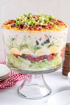 a layered salad in a glass dish on a table