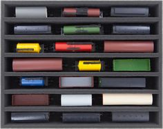 an assortment of different colored pencils and markers in a black box with dividers