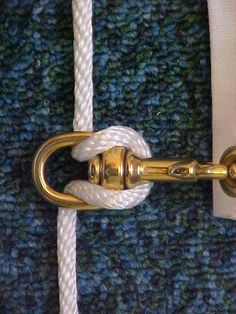 a close up of a white rope on a blue and green blanket with a gold handle