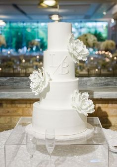 a three tiered white wedding cake with flowers on top