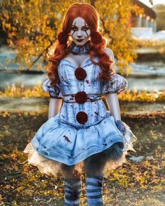 a woman with red hair and makeup is dressed up as a creepy doll in the woods