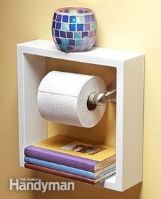 a toilet paper holder with two rolls of toilet paper on top of it and a vase next to it