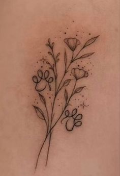 the back of a woman's shoulder with flowers and hearts tattoo on her left side