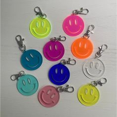 six key chains with different colored smiley faces on them