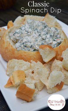 a white plate topped with bread chips and spinach dip