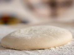 a doughnut sitting on top of a table covered in powdered sugar and flour