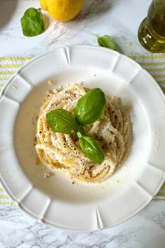 a white plate topped with pasta and basil