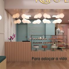 the interior of a bakery with clouds hanging from the ceiling and cakes in the display case