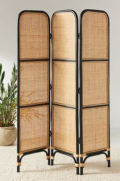 a room divider made out of wood and rattan with black trimmings